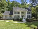 Stately white brick home with gray shutters, complemented by lush landscaping and a charming walkway at 117 Queensferry Rd, Cary, NC 27511