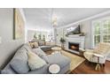Cozy living room with fireplace, plush seating, and open layout to kitchen, perfect for gatherings at 117 Queensferry Rd, Cary, NC 27511