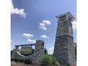 Stone entrance to Holding Village community sign under a bright sky with fluffy clouds at 1218 S Franklin St, Wake Forest, NC 27587