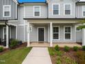 Inviting townhome featuring a covered porch with white pillars and a manicured lawn at 1218 S Franklin St, Wake Forest, NC 27587