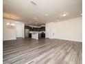Open-concept living room featuring wood-look flooring and seamlessly flowing into a modern kitchen area at 1218 S Franklin St, Wake Forest, NC 27587