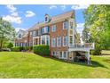 Charming brick home features a side deck, manicured lawn, and mature trees at 12527 Bellstone Ln, Raleigh, NC 27614