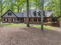 Traditional brick home featuring a lush, green lawn with trees at 12537 Birchfalls Dr, Raleigh, NC 27614