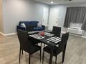 Dining area with black chairs and table setting, a grey sofa and a white door at 130 S Estes Dr # C-5, Chapel Hill, NC 27514