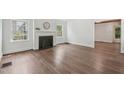 Bright living room featuring a classic fireplace, hardwood floors, and ample natural light from large windows at 1316 Glenwood Ave, Raleigh, NC 27605