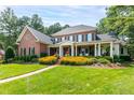 Elegant brick home boasts a sprawling lawn and charming covered porch at 1501 Samuel Wait Ln, Wake Forest, NC 27587