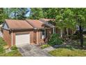 Aerial view showcasing the brick exterior, attached garage, and well-manicured lawn at 1612 Regency Dr, Burlington, NC 27215