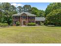 Charming two-story brick home with lush green lawn and mature trees under a clear sky at 170 Homestead Rd, Angier, NC 27501
