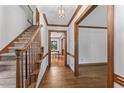 Foyer with hardwood floors, staircase, and view into dining area with natural light at 1705 Bridgeport Dr, Raleigh, NC 27615
