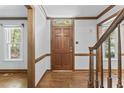 Open foyer featuring hardwood floors, dark wood trim, and a solid wood door at 1705 Bridgeport Dr, Raleigh, NC 27615