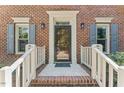 Front door exterior close up with gray shutters and a white railing leading up to the entrance at 1705 Bridgeport Dr, Raleigh, NC 27615