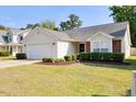 Charming home with a two-car garage, well-kept lawn, and mature landscaping at 1826 Heisser Ln, Fuquay Varina, NC 27526