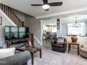 Cozy living room with staircase, modern furnishings, and neutral color scheme at 1909 Whirlaway Ct., Cary, NC 27519