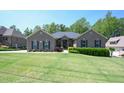 Charming single-story home with well-manicured lawn, mature trees, and beautiful shrubbery at 197 W Paige Wynd Dr, Angier, NC 27501
