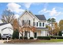 Inviting home with neat front yard landscaping and traditional facade featuring complementary green shutters and a peaked roof at 2014 Silky Dogwood Trl, Apex, NC 27502