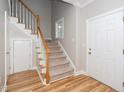 Bright foyer showcasing hardwood floors and a carpeted staircase, leading to the upper level of the home at 2014 Silky Dogwood Trl, Apex, NC 27502