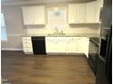 Well-lit kitchen featuring white cabinetry, granite countertops, and modern appliances on new flooring at 202 Redstone Ct, Gibsonville, NC 27249