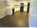 Spacious kitchen with white cabinets, stainless steel appliances, and new wood flooring, great for cooking at 202 Redstone Ct, Gibsonville, NC 27249