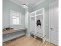Mudroom with storage lockers, a bench, a desk, hardwood floors, and a window for natural light at 2086 Amalfi Pl, Apex, NC 27502