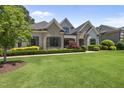Inviting home with lush green lawn and manicured landscaping, with a mix of stone and siding facade at 209 Preston Retreat Ln, Cary, NC 27513