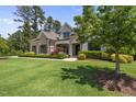 Charming home showcasing a manicured lawn, stone facade, and mature trees in a serene setting at 209 Preston Retreat Ln, Cary, NC 27513