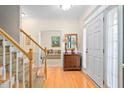 Bright foyer with hardwood floors, staircase, and a view into the living room at 210 Presidents Walk Ln, Cary, NC 27519