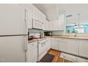 A spacious kitchen with white cabinets, modern appliances, and wood flooring at 2105 Metacomet Way, Raleigh, NC 27604