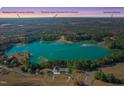 Stunning aerial view showcasing a beautiful lake house surrounded by lush trees and natural beauty at 215 Collins Rd, Lillington, NC 27546