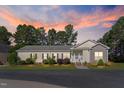 Home featuring a cozy front porch and tasteful landscaping, set against a beautiful sunset sky at 215 Collins Rd, Lillington, NC 27546