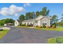 Charming home with well-maintained landscaping, an asphalt driveway, and a detached garage with mature trees at 215 Collins Rd, Lillington, NC 27546