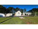 A detached two-car garage complements this home's exterior with a sunny lawn and trees in the background at 215 Collins Rd, Lillington, NC 27546