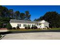 Charming, ranch-style home with a manicured lawn, stylish shutters, and a welcoming entrance at 215 Collins Rd, Lillington, NC 27546