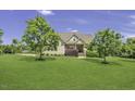 Traditional two-story home featuring a lush front lawn and mature trees creating a picturesque setting at 25 Westbourne Ln, Youngsville, NC 27596