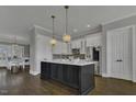 Spacious kitchen with a large island, stainless appliances, modern lighting, and hardwood floors at 25 Westbourne Ln, Youngsville, NC 27596