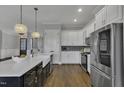 Bright kitchen features a large island, stainless steel appliances, and custom cabinets at 25 Westbourne Ln, Youngsville, NC 27596