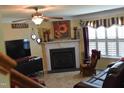 Cozy living room with fireplace, ceiling fan, and large TV, perfect for relaxing and entertaining at 259 Brassfield Dr, Burlington, NC 27217
