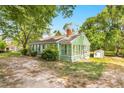 Cozy single-story home with a green exterior, a sunroom, and a storage shed at 2677 Nc-39, Henderson, NC 27537
