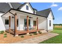 Inviting front porch features wood flooring, ceiling fans, and comfortable rocking chairs at 2775 Eagles Roost Trl, Burlington, NC 27217