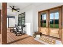 Cozy front porch featuring rocking chairs, wood columns, and a stylish double door at 2775 Eagles Roost Trl, Burlington, NC 27217