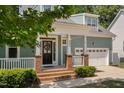 Inviting front porch with brick steps and pillars offers a warm welcome to this lovely home at 304 Nelson Ln, Clayton, NC 27527