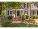 A welcoming front entrance with brick steps, white railings, and a black front door at 3113 Chelmshire Ct, Raleigh, NC 27610