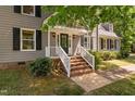 Inviting front entrance with brick steps, white railings, and a black front door and trimmed bushes at 3113 Chelmshire Ct, Raleigh, NC 27610