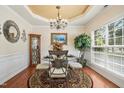 Elegant dining room with a glass table, chandelier, and large window, perfect for gatherings at 3633 Willow Stone Ln, Wake Forest, NC 27587