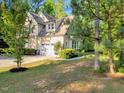 View of the side of the house, showing a two-car garage, driveway, and lush landscaping at 3650 Brooks Bnd, Franklinton, NC 27525