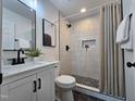Modern bathroom featuring black fixtures, tiled shower with niche, and unique flooring at 3907 Inwood Dr, Durham, NC 27705
