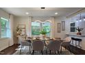 Elegant dining room with modern light fixture, large windows, and seating for six at 3907 Inwood Dr, Durham, NC 27705
