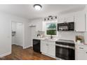 Bright kitchen featuring white cabinets, stainless steel appliances, and hardwood flooring at 3907 Inwood Dr, Durham, NC 27705
