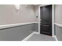 Condo hallway with a gray-toned walls, carpet, and a black door at 400 W North St # 1430, Raleigh, NC 27603