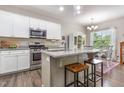 Bright kitchen with white cabinets, stainless steel appliances, granite countertops, and an island with a dining area at 420 Cherry St, Fuquay Varina, NC 27526