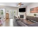 Cozy living room with a fireplace, modern furnishings, a ceiling fan, and wood flooring offering a comfortable living space at 420 Cherry St, Fuquay Varina, NC 27526